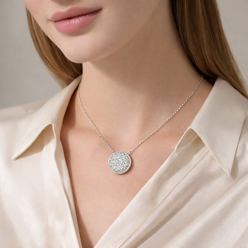 Close-up of a woman wearing a diamond necklace with a pave pendant.