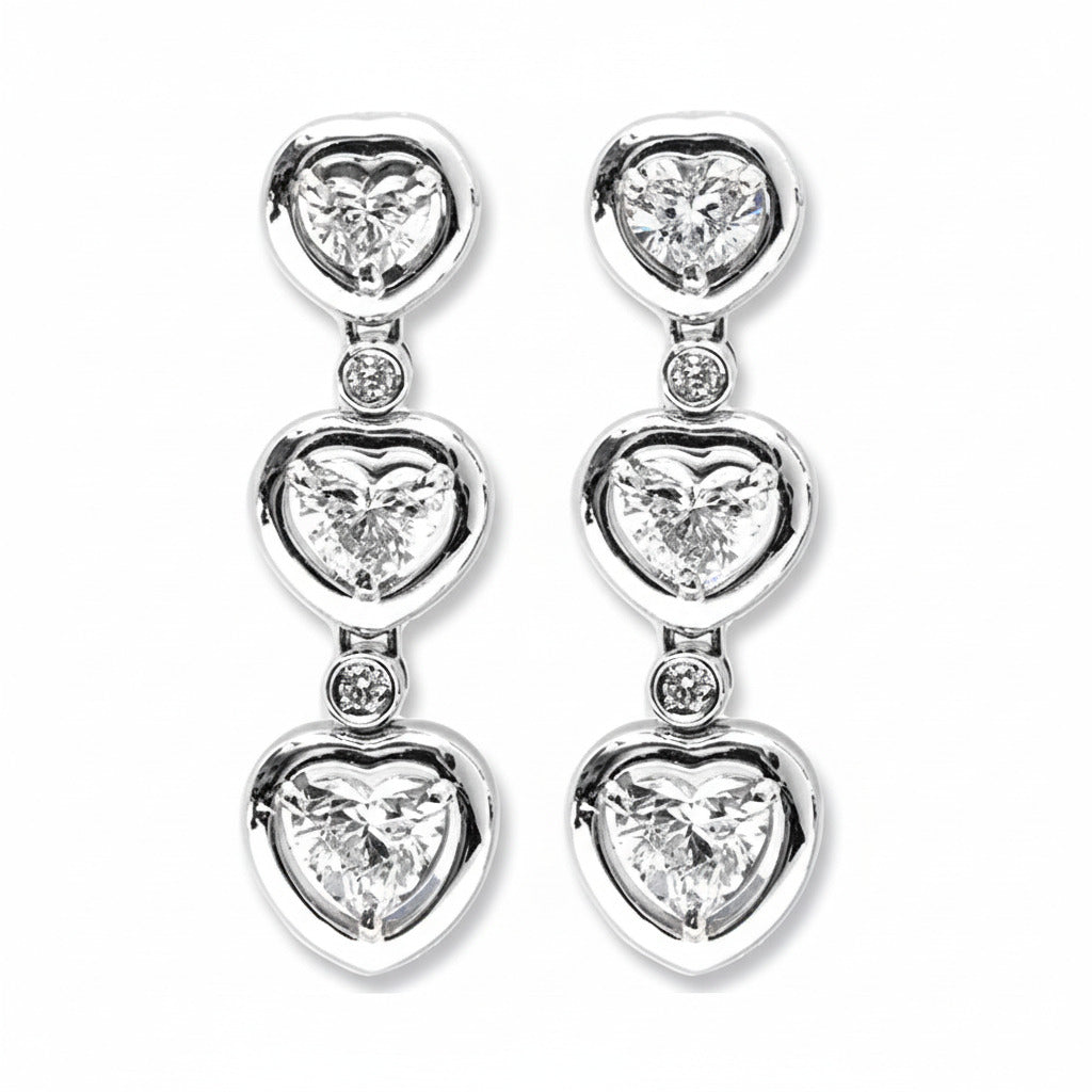 A pair of heart-shaped diamonds drop earrings made with white gold, featuring multiple heart brilliants.